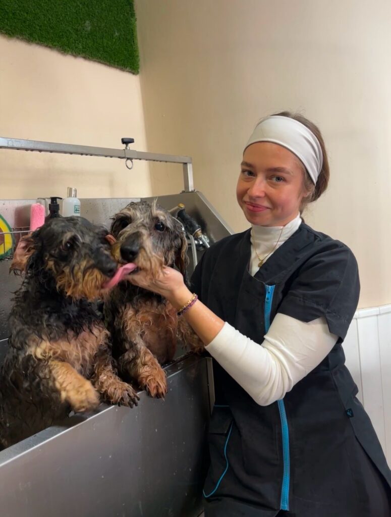 mujer acariciando a dos perros preciosos